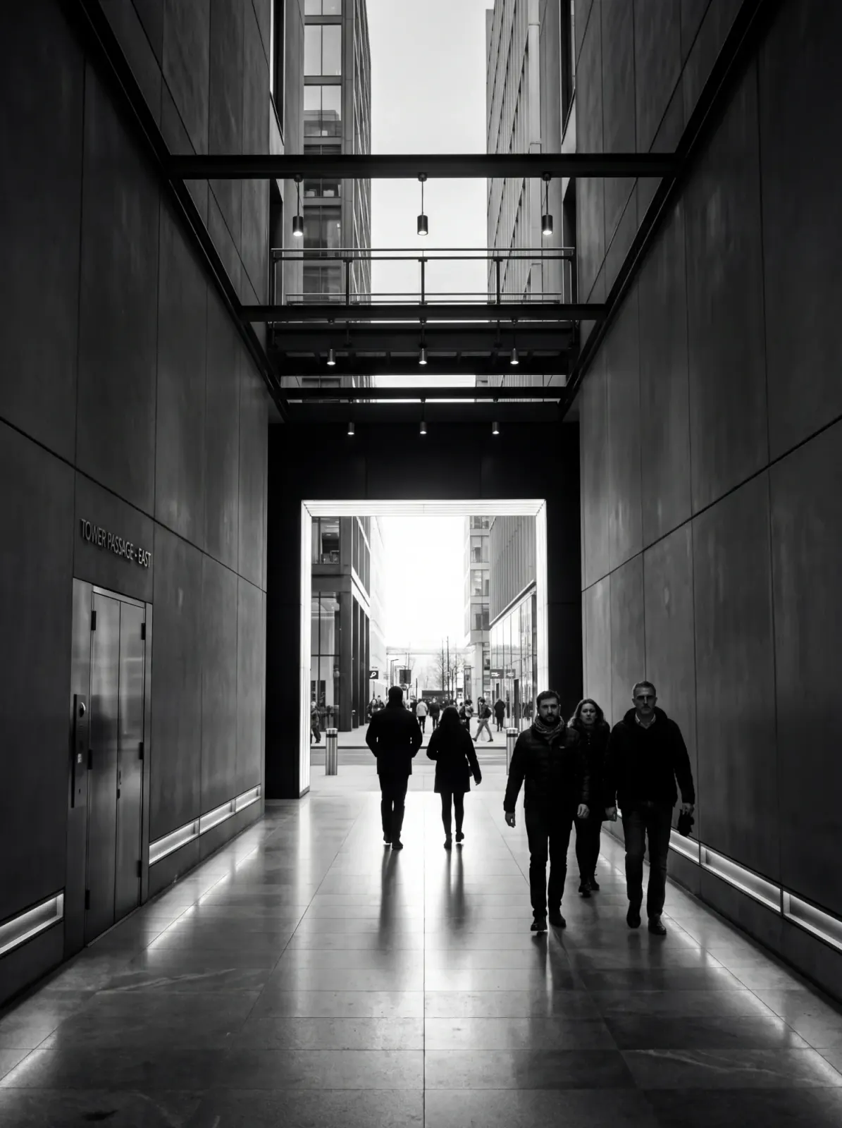 Mensen lopen door een overdekte passage tussen twee kantoortorens